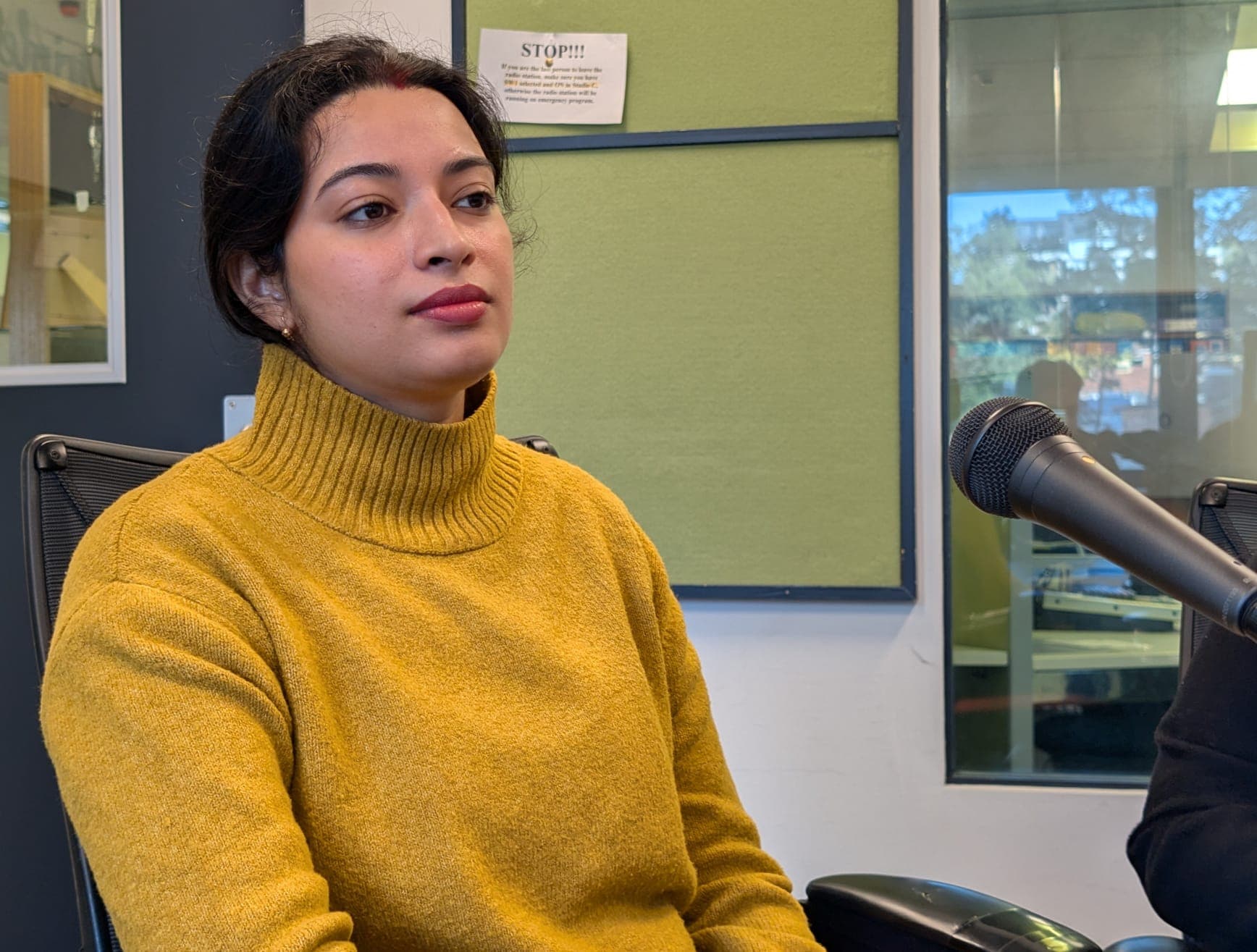 A Mithila Gunj participant seated beside a microphone in the radio studio